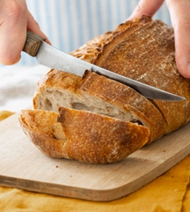 Slicing crusty sourdough bread image